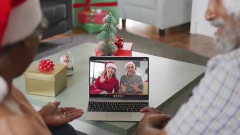 Happy-african-american-senior-couple-on-video-call-with-senior-friends-at-christmas