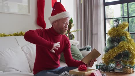 Glücklicher-Afroamerikanischer-Albino-Mann-Mit-Weihnachtsmütze,-Der-Zu-Weihnachten-Einen-Videoanruf-Macht