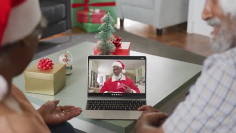 Feliz-Pareja-Afroamericana-De-Edad-Avanzada-En-Videollamada-En-Una-Computadora-Portátil-Con-Santa-Claus-En-Navidad