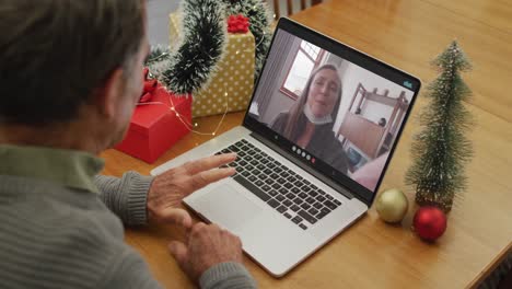 Happy-caucasian-senior-man-on-video-call-with-adult-daughter-at-christmas-time