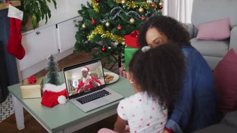 Afroamerikanische-Mutter-Und-Tochter-Im-Videoanruf-Mit-Dem-Weihnachtsmann-Zur-Weihnachtszeit