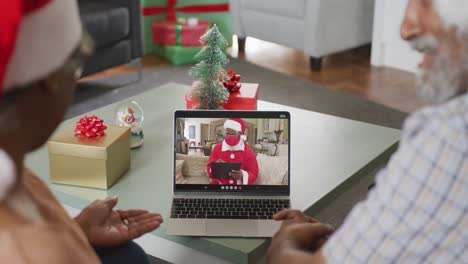 Happy-african-american-senior-couple-on-video-call-with-santa-claus-at-christmas