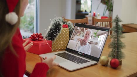 Happy-caucasian-woman-on-video-call-with-grandmother-at-christmas-time