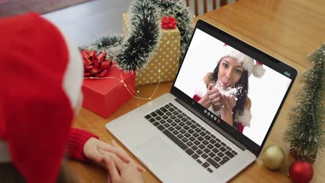Caucasian-woman-on-video-call-on-laptop-with-female-friend-at-christmas-time