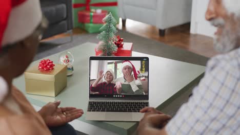 Happy-african-american-senior-couple-on-video-call-with-adult-son-and-grandson-at-christmas