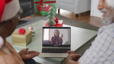 Happy-african-american-senior-couple-on-video-call-with-senior-female-friend-at-christmas-time