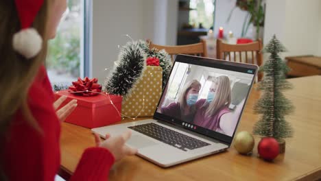 Kaukasische-Frau-Mit-Weihnachtsmütze,-Die-Zu-Weihnachten-Zu-Hause-Einen-Videoanruf-Auf-Dem-Laptop-Führt