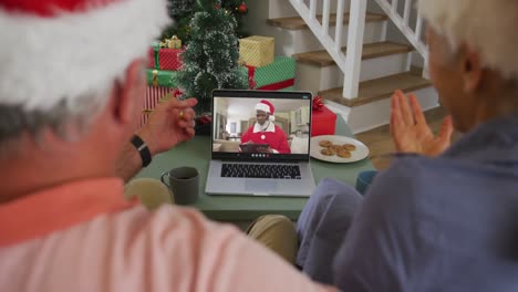 Happy-african-american-senior-couple-on-video-call-with-sant-a-claus-at-christmas