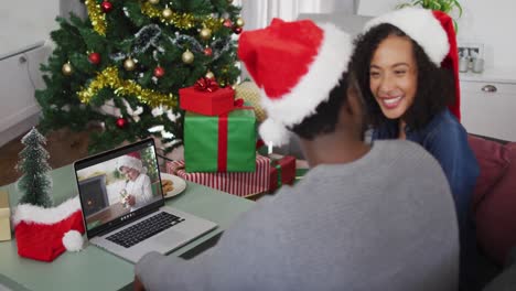 Glückliches-Afroamerikanisches-Paar-Bei-Einem-Videoanruf-Auf-Einem-Laptop-Mit-Einem-Jungen-In-Weihnachtsmütze-Zur-Weihnachtszeit