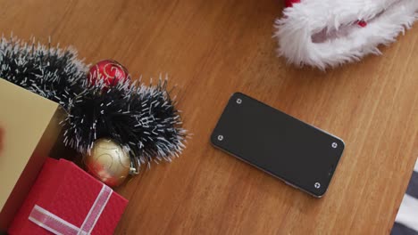 Smartphone-Mit-Weihnachtsdekoration-Und-Weihnachtsgeschenken-Auf-Dem-Tisch