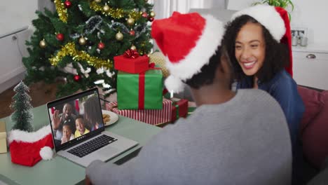 Happy-african-american-couple-on-video-call-on-laptop-with-family-at-christmas-time
