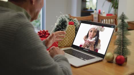 Happy-caucasian-senior-man-on-video-call-with-female-friend-at-christmas-time