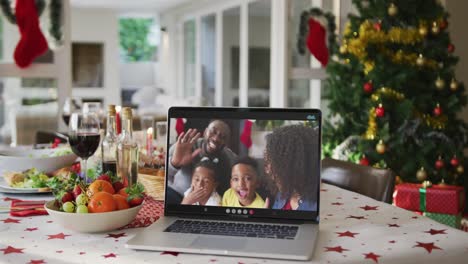 Feliz-Familia-Afroamericana-En-Una-Computadora-Portátil-Tumbada-En-La-Mesa-De-Navidad