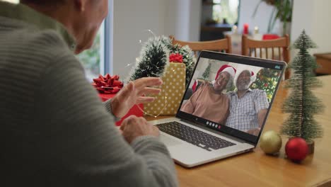 Caucasian-senior-man-on-video-call-with-senior-friends-at-christmas-time