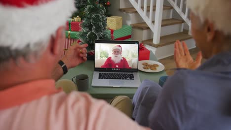 Happy-senior-caucasian-couple-on-video-call-on-laptop-with-santa-claus-at-christmas-time