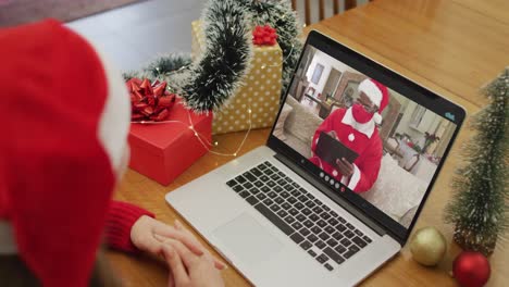 Caucasian-woman-on-video-call-with-santa-claus-at-christmas-time