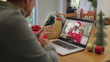 Caucasian-senior-man-on-video-call-with-santa-claus-at-christmas-time