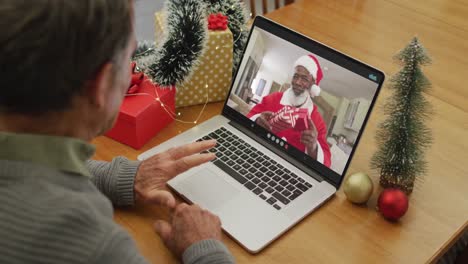 Hombre-Mayor-Caucásico-En-Videollamada-En-Una-Computadora-Portátil-Con-Papá-Noel-En-Navidad