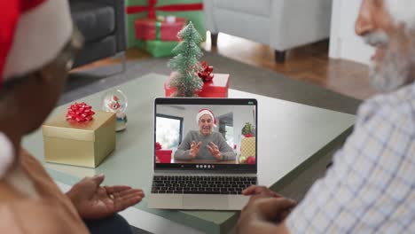 Happy-african-american-senior-couple-on-video-call-with-senior-male-friend-at-christmas