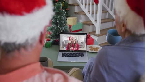 Happy-african-american-senior-couple-on-video-call-with-granddaughter-at-christmas