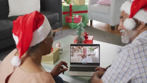 Happy-senior-african-american-couple-on-video-call-with-senior-female-friend-at-christmas-time
