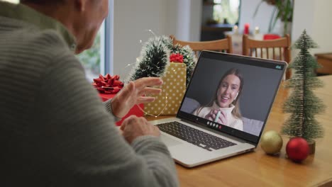 Happy-caucasian-senior-man-on-video-call-on-laptop-with-adult-daughter-at-christmas-time