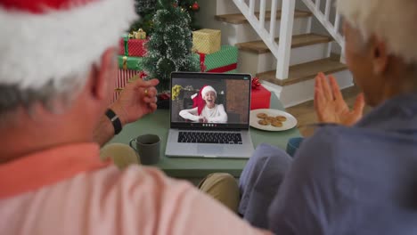 Happy-caucasian-senior-couple-couple-on-video-call-with-boy-at-christmas-time