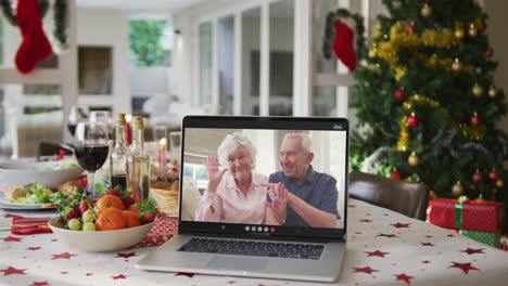Happy-caucasian-senior-couple-on-laptop-lying-on-christmas-table