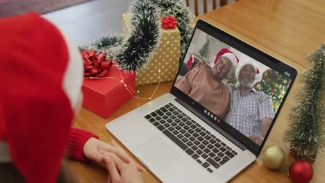Happy-caucasian-woman-on-video-call-with-female-friends-at-christmas-time