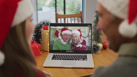 Glückliches-Kaukasisches-älteres-Paar-Bei-Einem-Videoanruf-Mit-älteren-Freunden-Zur-Weihnachtszeit