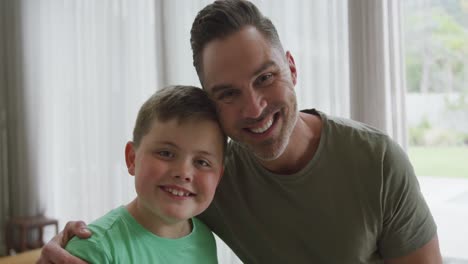 Portrait-of-caucasian-father-and-son-smiling-in-the-living-room-at-home