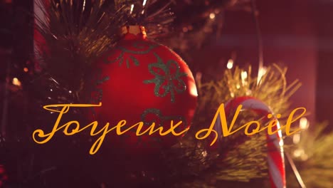 Animation-of-joyeux-noel-text-over-christmas-decorations