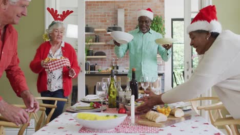 Happy-group-of-diverse-senior-friends-celebrating-meal-at-christmas-time