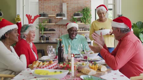 Fröhliche-Gruppe-Verschiedener-älterer-Freunde,-Die-Das-Essen-Zur-Weihnachtszeit-Feiern