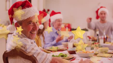 Gelbe-Sternsymbole-Fallen-Auf-Einen-Lächelnden-Kaukasischen-älteren-Mann,-Der-Während-Des-Weihnachtsessens-Zu-Abend-Isst