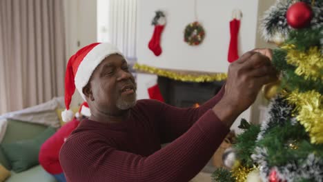 Glückliches-älteres-Afroamerikanisches-Paar,-Das-Den-Weihnachtsbaum-Im-Wohnzimmer-Schmückt