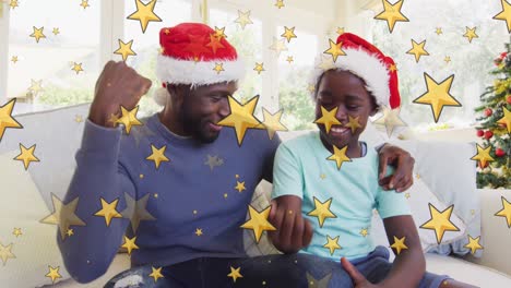Yellow-stars-falling-against-african-american-father-and-son-waving-during-christmas