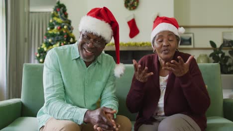 Glückliches-Afroamerikanisches-Seniorenpaar-In-Weihnachtsmützen-Bei-Einem-Videoanruf-Zur-Weihnachtszeit