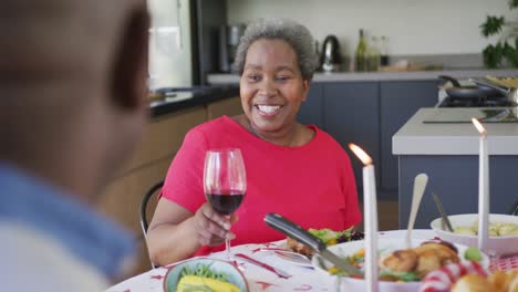 Glückliche-Afroamerikanische-Seniorin,-Die-Mit-Ihrem-Partner-In-Der-Küche-Isst