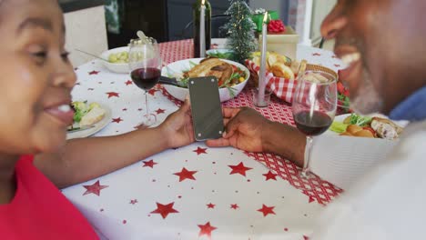 Glückliches-Afroamerikanisches-Seniorenpaar-Bei-Einem-Videoanruf-Auf-Dem-Smartphone-Mit-Kopierplatz-Zur-Weihnachtszeit