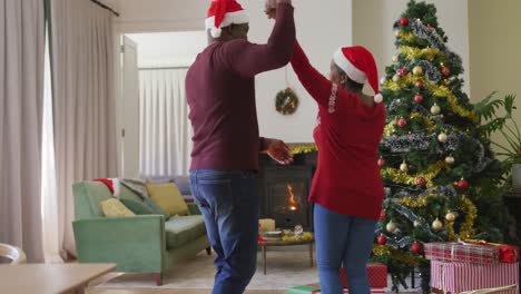 Glückliches-älteres-Afroamerikanisches-Paar,-Das-Den-Weihnachtsbaum-Im-Wohnzimmer-Schmückt