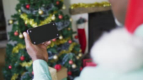 Fröhliche-ältere-Frau-Mit-Gemischter-Abstammung-Bei-Einem-Videoanruf-Auf-Dem-Smartphone-Mit-Kopierplatz-Zur-Weihnachtszeit