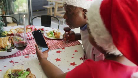 Glückliches-Afroamerikanisches-Seniorenpaar-Bei-Einem-Videoanruf-Auf-Dem-Smartphone-Mit-Kopierplatz-Zur-Weihnachtszeit