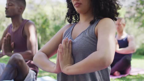 Group-of-diverse-young-people-meditating-and-practicing-yoga-together-at-the-park