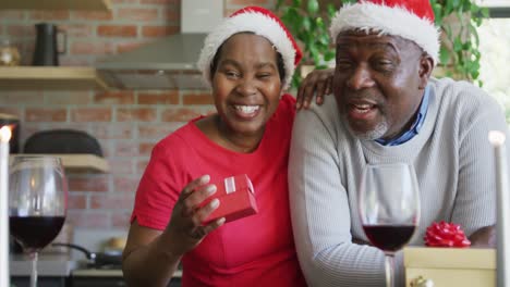 Glückliches-Afroamerikanisches-Seniorenpaar-In-Weihnachtsmützen-Bei-Einem-Videoanruf-Zur-Weihnachtszeit