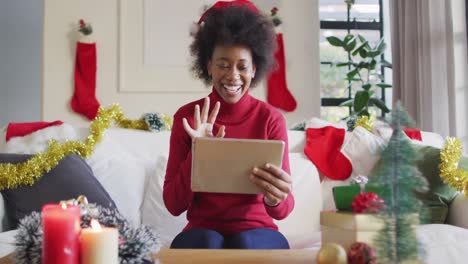 Happy-african-american-woman-wearing-santa-hat-making-video-call