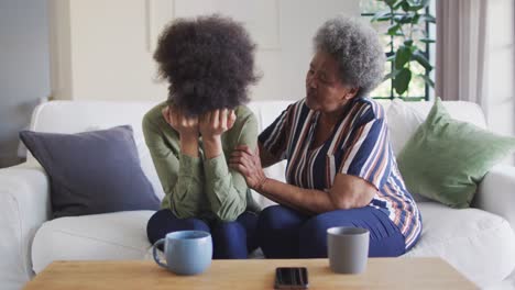 Afroamerikanische-ältere-Mutter-Tröstet-Traurige,-Weinende-Erwachsene-Tochter-Zu-Hause,-Zeitlupe