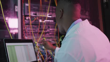 Técnico-Informático-Afroamericano-Que-Utiliza-Una-Computadora-Portátil-Trabajando-En-La-Sala-De-Servidores-De-Negocios