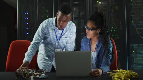 Afroamerikanische-Computertechniker-Nutzen-Laptop-Und-Arbeiten-Im-Serverraum-Des-Unternehmens