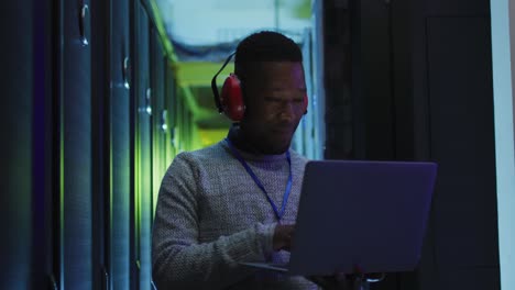 Técnico-Informático-Afroamericano-Que-Utiliza-Una-Computadora-Portátil-Trabajando-En-La-Sala-De-Servidores-De-Negocios